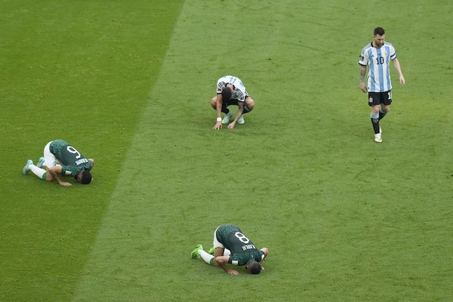 Superstar Argentina Lionel Messi (kanan) tampak sedih sementara dua pemain Arab Saudi melakukan sujud syukur di laga pembuka Grup B Piala Dunia 2022 di Lusail Stadium.