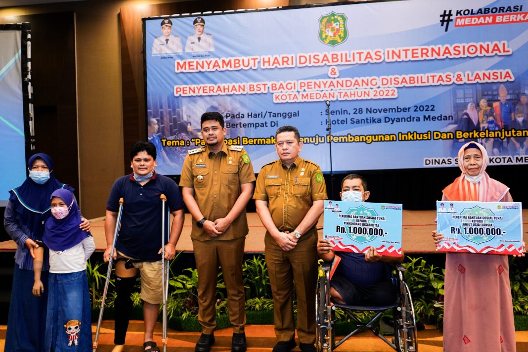 Wali Kota Medan Bobby Nasution foto bersama dengan lainnya saat hadir dalam acara menyambut Hari Disabilitas Internasional dan penyerahan BST bagi penyandang disabilitas dan lansia di Hotel Santika Dyandra Medan, Jalan Kapten Maulana Lubis.