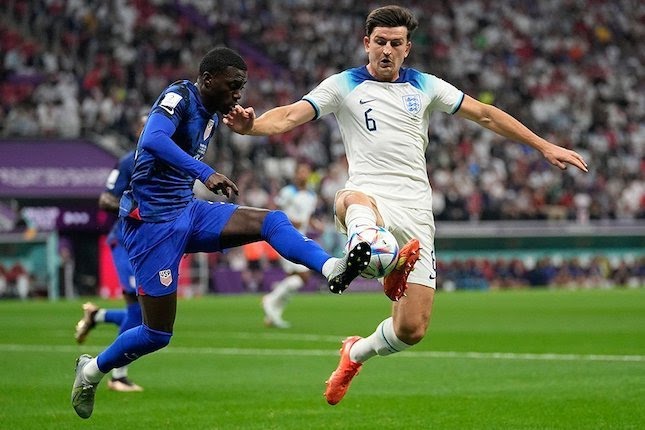 Timothy Weah berduel dengan Harry Maguire di laga Inggris vs Amerika Serikat, Piala Dunia 2022.