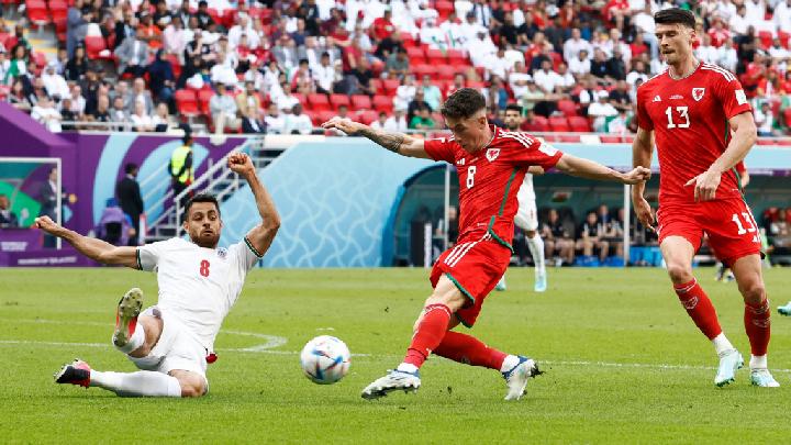 Pemain Wales Harry Wilson melakukan tendangan yang berusaha dihadang pemain Iran Morteza Pouraliganji dalam pertandingan Grup B Piala Dunia 2022 di Stadion Ahmad Bin Ali, Al Rayyan, Qatar.