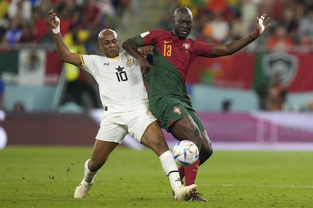 Duel perebutan bola antara penyerang Ghana, Andre Ayew menghadapi bek tengah Portugal, Danilo Pereira pada laga pertama Grup H Piala Dunia 2022.