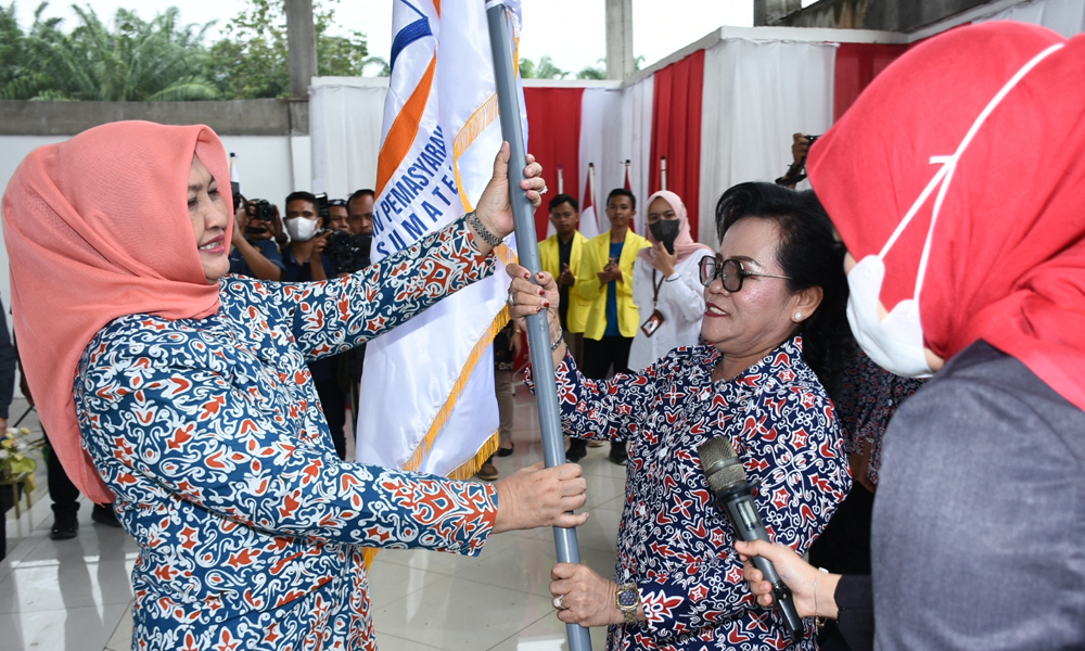 Ketua GPMB Sumut Nawal Lubis menyerahkan pataka kepada Ketua GPMB Simalungun Ratnawati Sidabutar saat melantik kepengurusan GPMB Kabupaten Simalungun periode 2022-2026 di Gedung Islamic Center Perdagangan, Kecamatan Bandar, Kabupaten Simalungun, Rabu (7/12/2022).