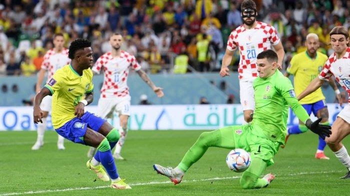 Kiper Kroasia Dominik Livakovic saat menghalau bola tendangan dari penyerang Brasil, Vinisius Jr dalam pertandingan perempat final piala dunia 2022 di Education City Stadium.