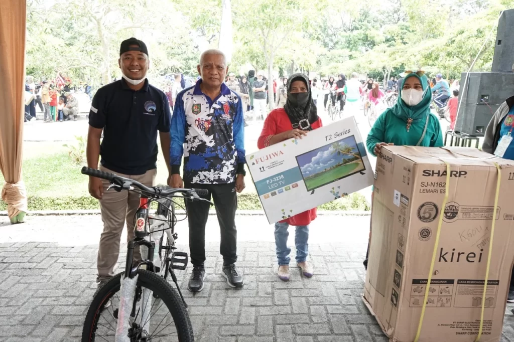 Bupati Asahan H Surya BSc foto bersama dengan lainnya usai pencabutan kupon lucky draw di Alun-Alun Kisaran, Minggu (4/12/2022).