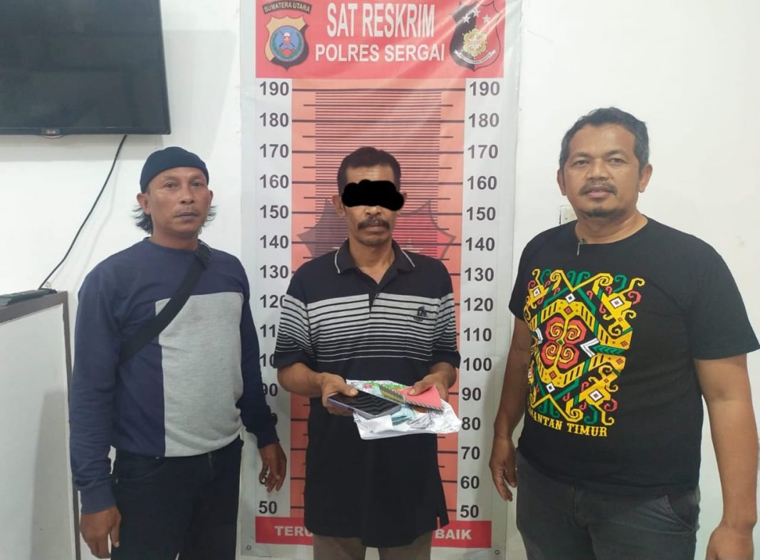 Personel Satreskrim, Aiptu L Torosky Manik dan Aiptu Dedy Asmono mengapit An (49), tersangka jurtul togel, saat diamankan di Satreskrim Polres Sergai.