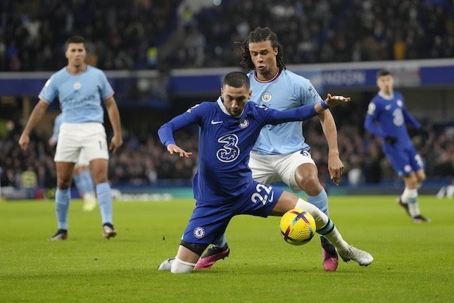 Penyerang sayap Chelsea, Hakim Ziyech menjaga bola dari rebutan bek tengah Manchester City, Manuel Akanji pada pekan ke-19 Liga Inggris 2022/2023.