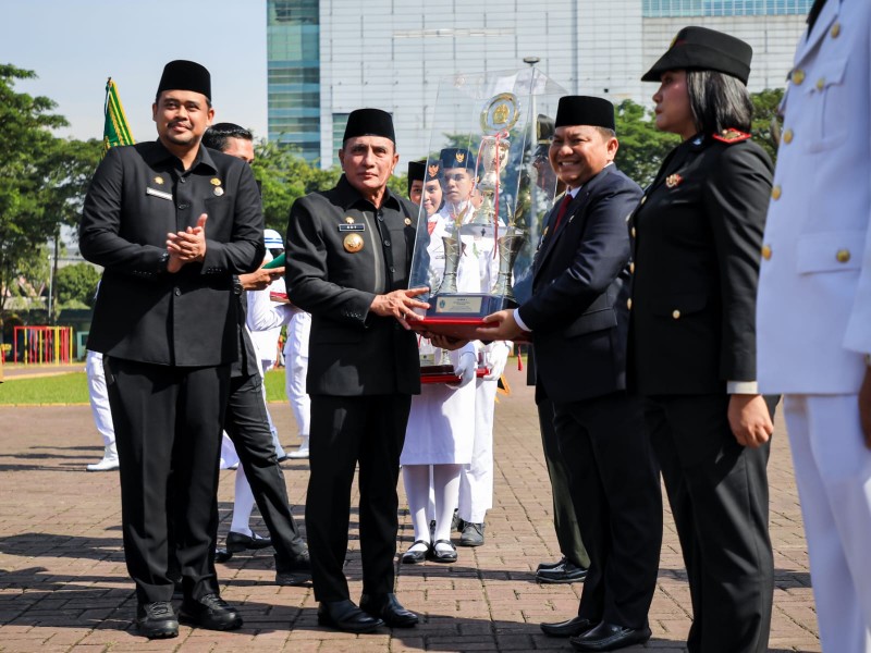 Gubernur Sumut Edy Rahmayadi bersama Wali Kota Medan Bobby Nasution kepada Harry Indrawan Tarigan (Camat Medan Tuntungan) dalam Upacara Penyerahan Tanggul Kecamatan Terbaik tingkat Provinsi Sumut kategori Kota tahun 2022 di Lapangan Benteng.