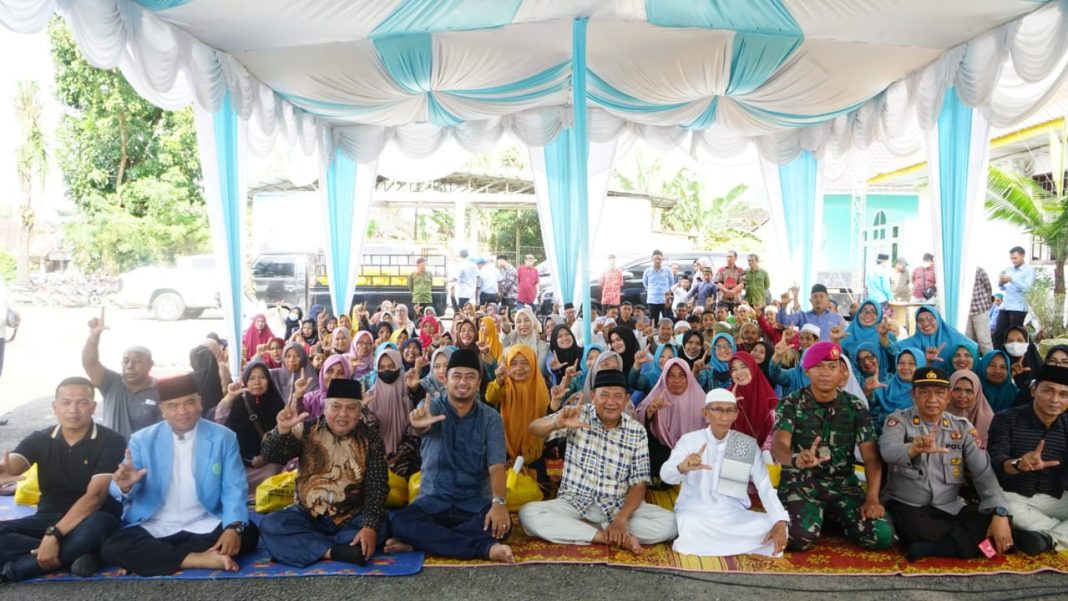 Plt Bupati Langkat H Syah Afandin SH foto bersama dengan lainnya usai menyerahkan santunan kepada Guru Ngaji Kampung se Teluk Aru, bertempat di Halaman Kantor Camat Sei Lepan, Kabupaten Langkat.