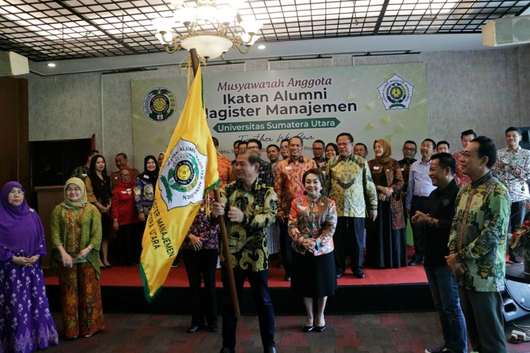 Tarman Hartono SE MM mengibarkan bendera IKA MM USU setelah dilantik menjadi Ketua IKA MM USU periode 2023-2026.