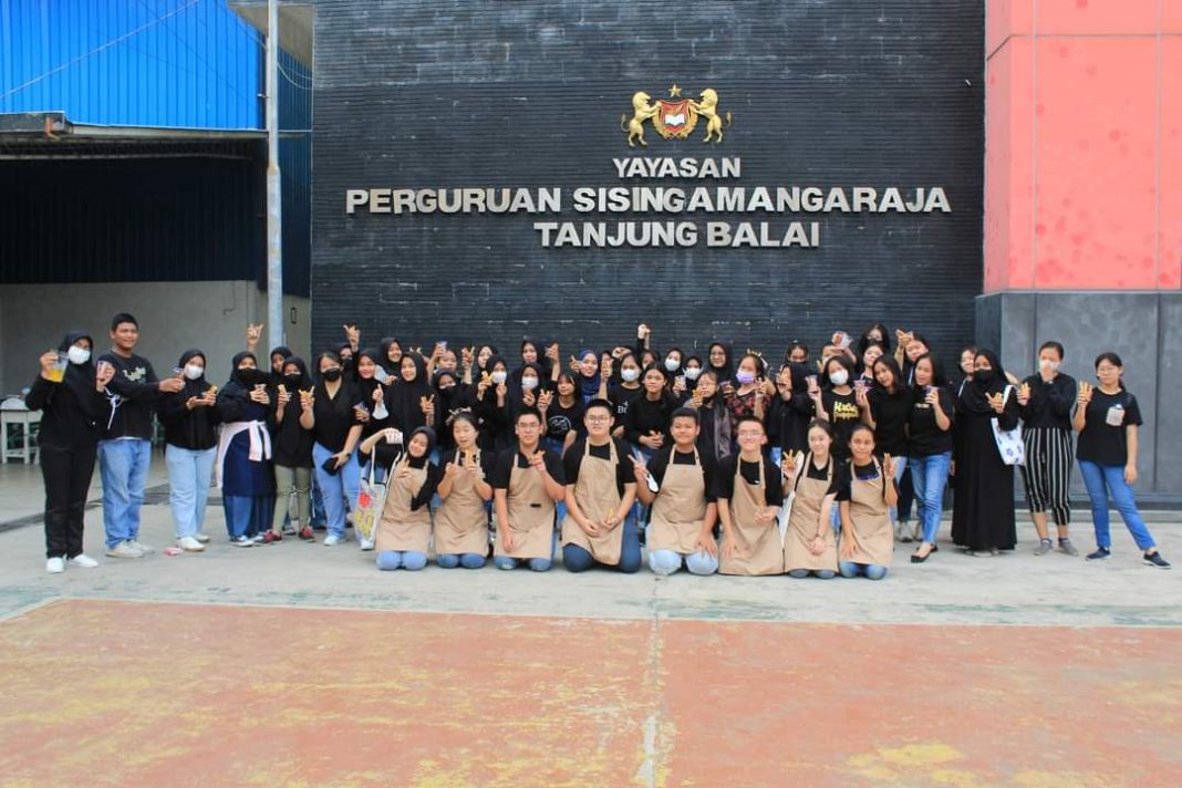 Seluruh anggota Club Tata Boga SMA Swasta Sisingamangaraja foto bersama di halaman sekolah.