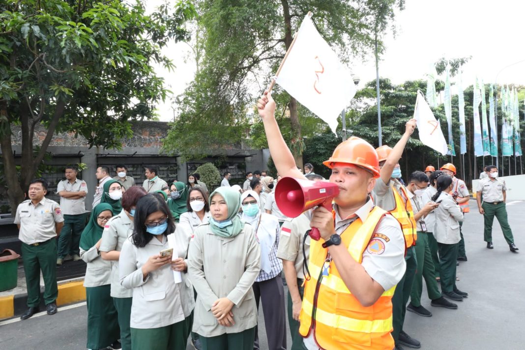 Manajer lantai selaku komandan regu penyelamat, sedang memberikan instruksi Para pegawai sedang melakukan evakuasi mandiri menuju titik kumpul saat simulasi evakuasi bencana gempa di Gedung Graha BNPB, Jakarta.