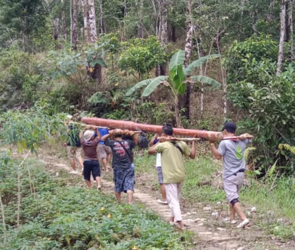 Petugas PLN adakalanya menggotong material untuk memasang listrik di daerah terpencil dan tertinggal karena belum ada jalan yang bisa dilintasi mobil.