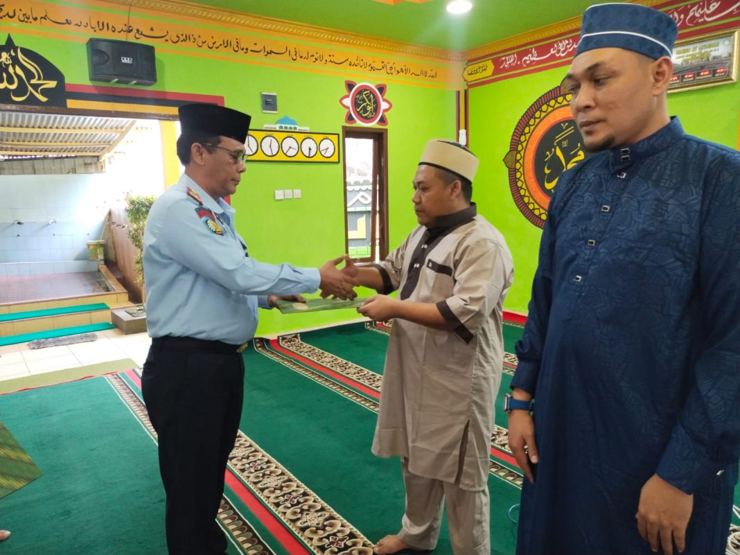 Kepala Lapas Narkotika Kelas IIA Pematangsiantar Robinson Perangin-angin menyerahkan remisi Idul Fitri kepada perwakilan warga binaan di Mesjid At Taubah.