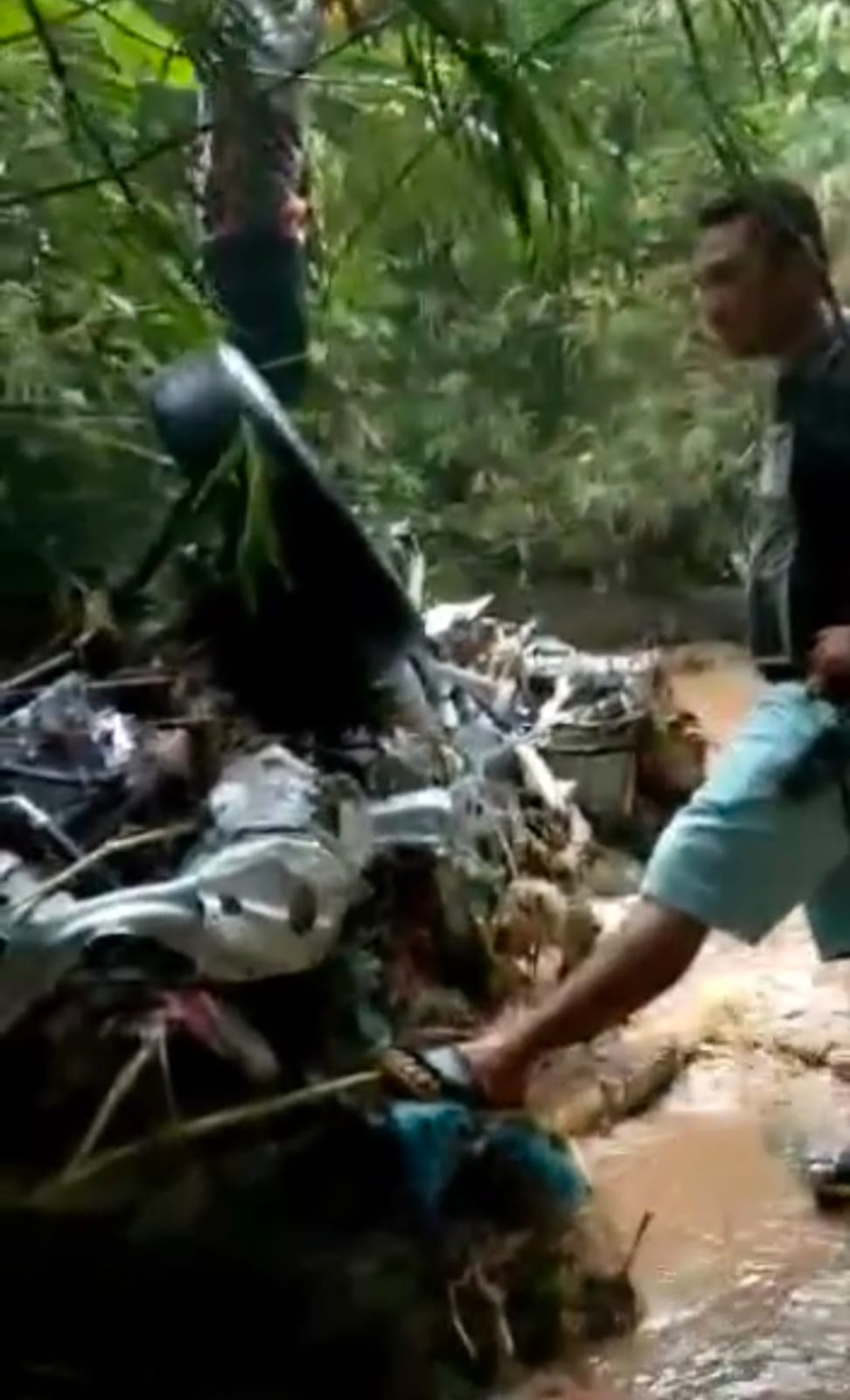 Mobil minibus warna putih yang hanyut terseret air sungai saat terjadinya banjir bandang di kawasan Sibolangit, tersangkut di bebatuan pemandian alam Lembah Naga Desa Sembahe, Kecamatan Sibolangit, Kabupaten Deliserdang.