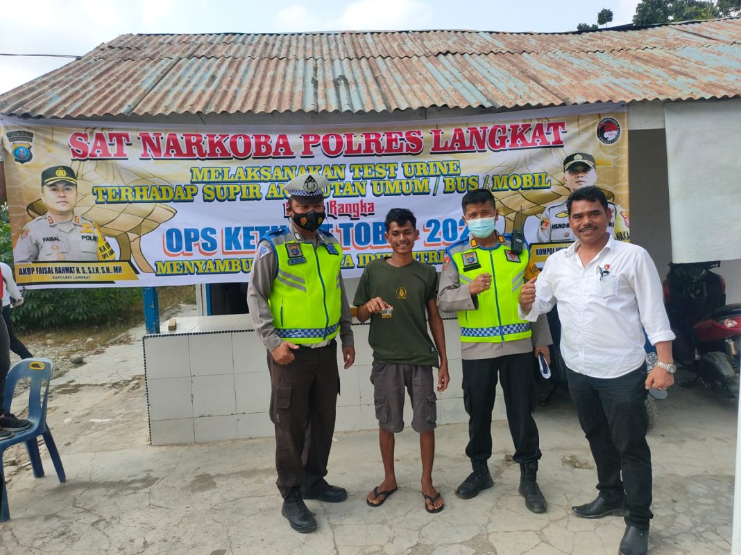 Salah seorang sopir angkutan umum (dua dari kiri) berfoto bersama personel Satres Narkoba Polres Langkat usai menjalani tes urin di Pos Pam III Terminal Pasar X Tanjung Beringin, Kecamatan Hinai, Kabupaten Langkat.