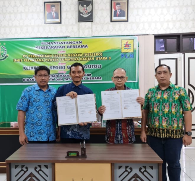 Manager PT PLN UPP Sumbagut 3 Joko Purnomo melakukan penandatanganan kesepakatan bersama dengan Bidang Keperdataan dan Tata Usaha Negara Kejaksaan Negeri Gunungsitoli dan kemudian memegang naskah yang diteken, Jumat (19/5/2023). (Dok/PLN)