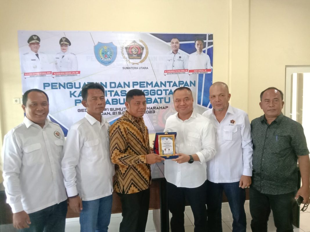 Pemberian plakat dari Ketua PWI Labuhanbatu Rony Afrizal kepada Ketua PWI Sumut Farianda Putra Sinik didampingi Sekretaris PWI Sumut SR Hamonangan Panggabean dan pengurus lainnya foto bersama, Senin (22/5/2023).