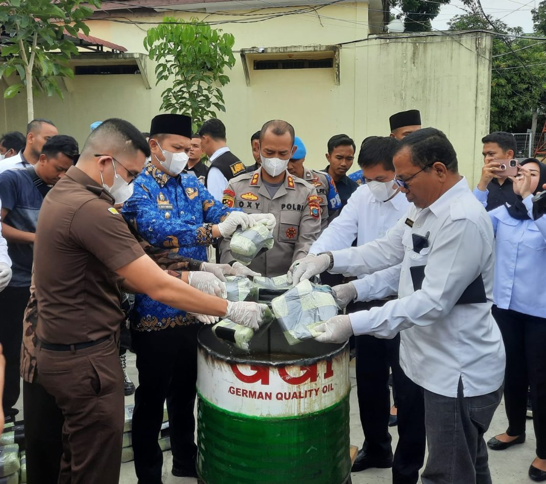 Kapolres Sergai AKBP Oxy Yudha Pratesta bersama Wakil Bupati H Adlin Tambunan, Kajari diwakili Jaksa Jhordy Nainggolan, Kabag Bin Opsnal Dit Narkoba Polda Sumut Kompol Abri Manday, dan Kasi Brantas BNNK Sergai Kompol Antonius Pangaribuan memasukkan sabu ke dalam air mendidih untuk dimusnahkan pada pemusnahan barang bukti narkotika jenis sabu yang digelar Polres Sergai, Senin (22/5/2023).