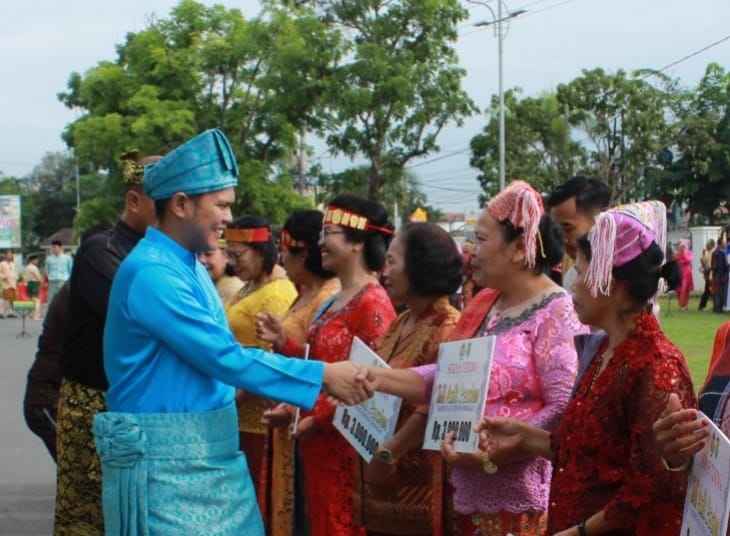 Wakil Bupati Sergai H Adlin Tambunan dengan mengenakan pakaian adat Melayu menyerahkan tali asih kepada para guru yang yang telah memasuki masa purna bakti pada peringatan Hardiknas di halaman Kantor Bupati Sergai di Sei Rampah.