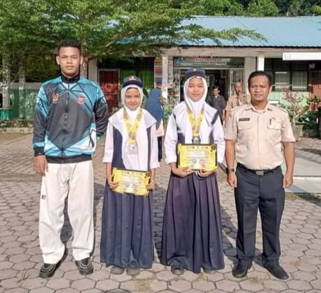 Kepala Sekolah SMPN 5 Kota Tanjungbalai, Muhammad Prana Adithya, berfoto bersama kedua siswi peraih medali perak di ajang ITC 2023 didampingi pelatih di halaman sekolah, Senin (5/6/2023).
