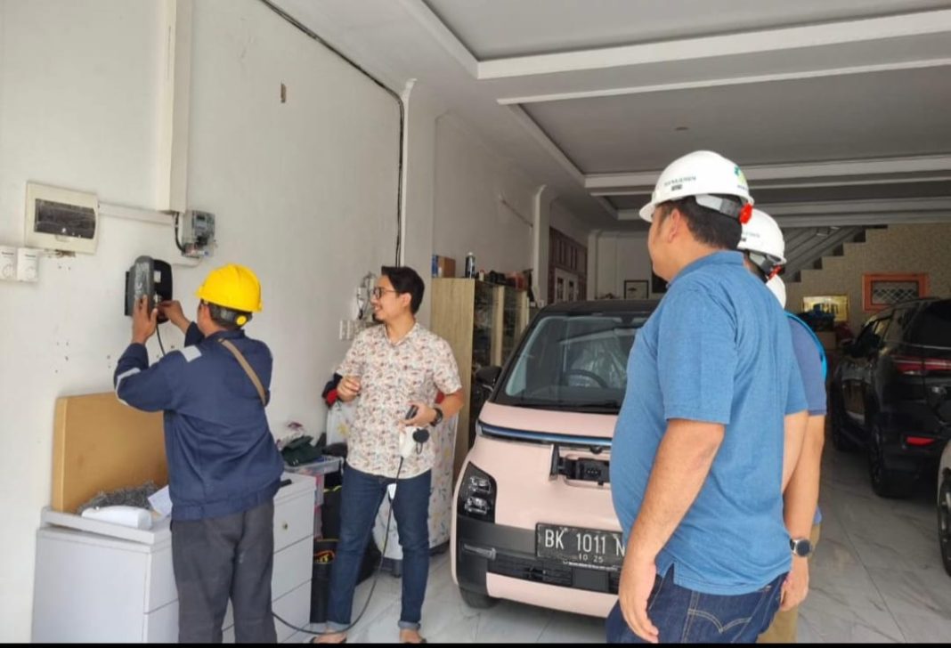 Manager ULP PLN Medan Baru H Hutapea bersama pengguna kendaraan listrik saat proses pemasangan home charging. (Dok/PLN)