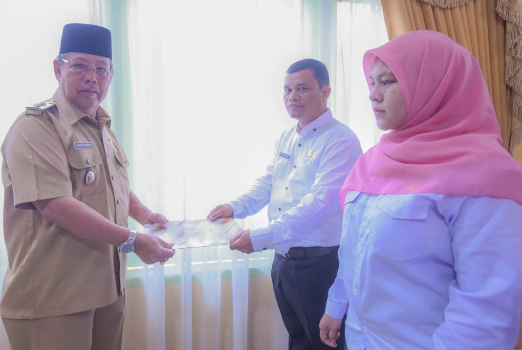 Wakil Wali Kota Padangsidimpuan Arwin Siregar sedang menyerahkan SK PPPK kepada yang mewakili guru SD dan guru SMP di Aula Kantor Wali Kota Padangsidimpuan, Senin (12/6/2023).
