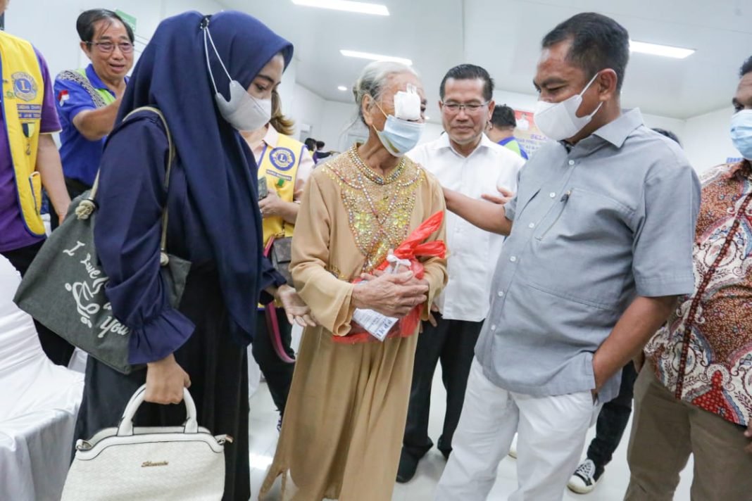 Bupati Sergai H Darma Wijaya menyapa warga yang baru menjalani operasi katarak saat menghadiri baksos yang digelar Lions Club di RSUD Sultan Sulaiman Seirampah, Minggu (18/6/2023).