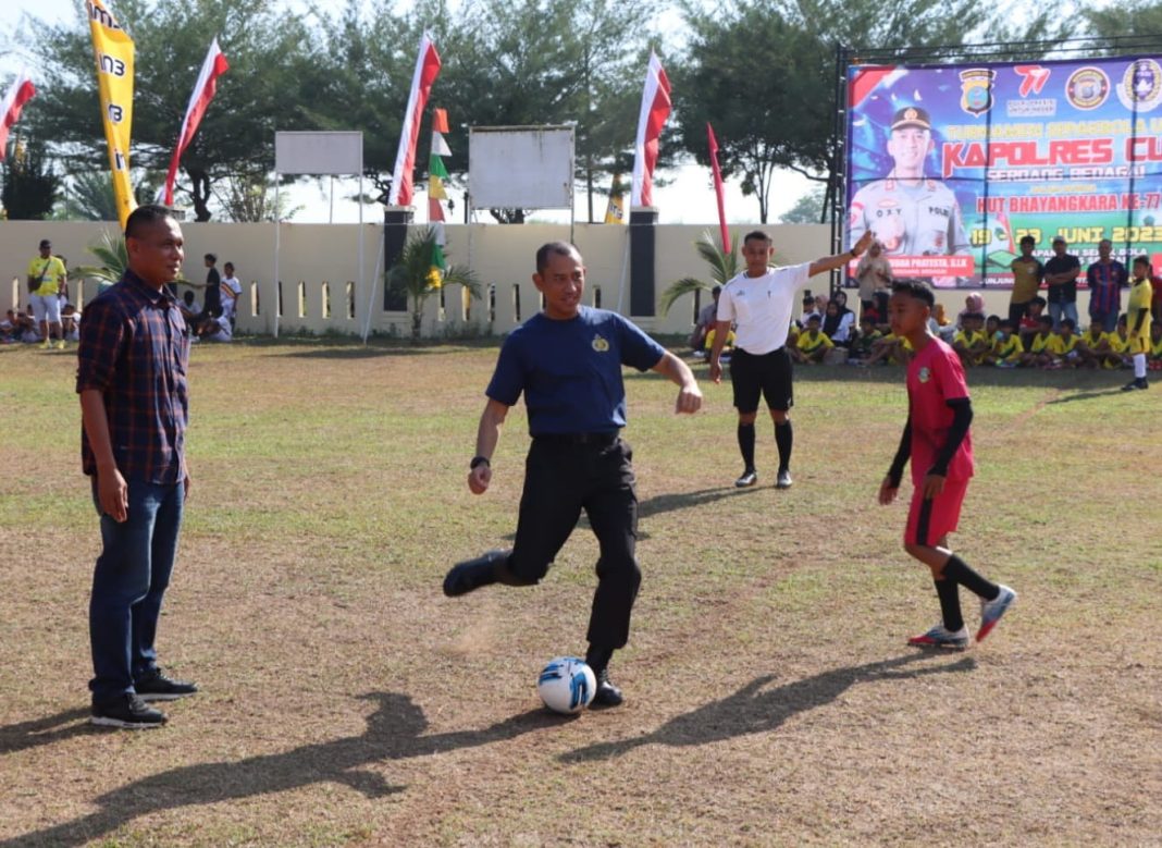 Kapolres Sergai AKBP Oxy Yudha Pratesta melakukan tendangan perdana tanda dimulainya turnamen sepak bola U-12 yang digelar Polres Sergai dalam rangkaian HUT ke-77 Bhayangkara, Selasa (20/6/2023). (Dok/Humas Polres Sergai)