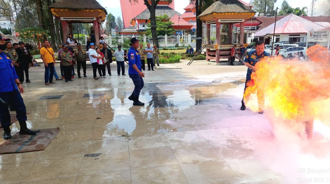 Kepala Satpol PP dan Damkar Gelora Fajar Purba SH MH mempraktekkan pemadaman api menggunakan alat pemadam kebakaran ringan (APAR) di hadapan peserta sosialisasi di halaman Kantor Camat Kabanjahe, Kamis (23/6/2023).