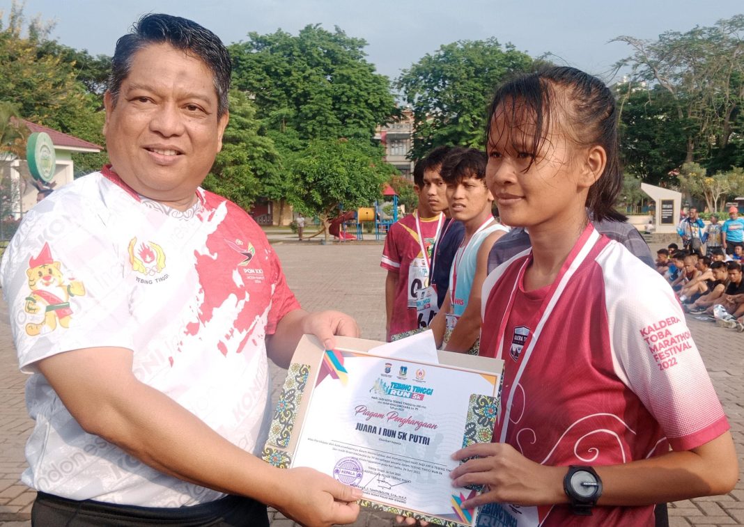Pj Wali Kota Tebingtinggi Drs Syarmadani MSi menyerahkan piagam kepada peserta yang juara 1 RUN 5K, Sabtu (24/6/2023).