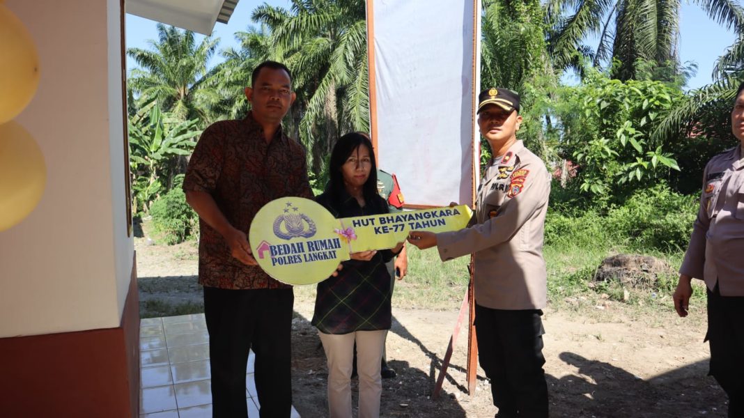 Wakapolres Kompol Hendri ND Barus menyerahkan kunci rumah kepada Sahat Perlindungan Tambunan di Lorong Murni, Kelurahan Perdamaian, Kecamatan Stabat, Kabupaten Langkat, Sabtu (8/7/2023). (Dok/Polres Langkat)