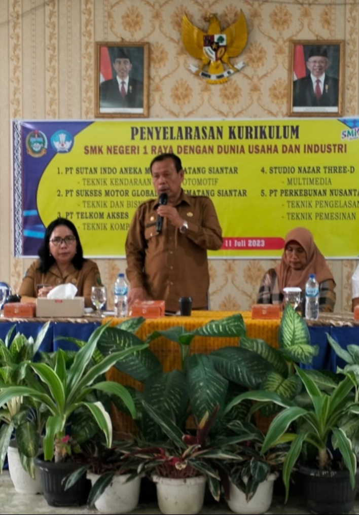 Kepala Cabang Dinas Pendidikan Wilayah VI Sumut Drs Ramadhan Zuhri Bintang (berdiri) didampingi Kepala SMK Negeri 1 Raya Erlinda Saragih menyampaikan kata sambutan pada kegiatan penyelarasan kurikulum bersama Dudi di Raya, Senin (10/7/2023).