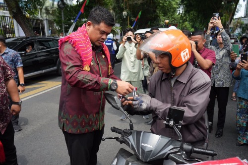 Wali Kota Medan Bobby Nasution langsung turun ke jalan membagikan Bendera Merah Putih kepada masyarakat yang melintas di depan Balai Kota Medan, beberapa hari yang lalu. (Dok/Kominfo Medan)