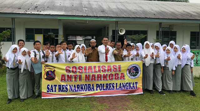 Personel Satres Narkoba Polres Langkat berfoto bersama usai memberikan edukasi tentang bahaya narkotika terhadap para pelajar SMAN 1 Hinai, Desa Cempa, Kecamatan Hinai, Kabupaten Langkat, Senin (17/7/2023). (Dok/Polres Langkat)