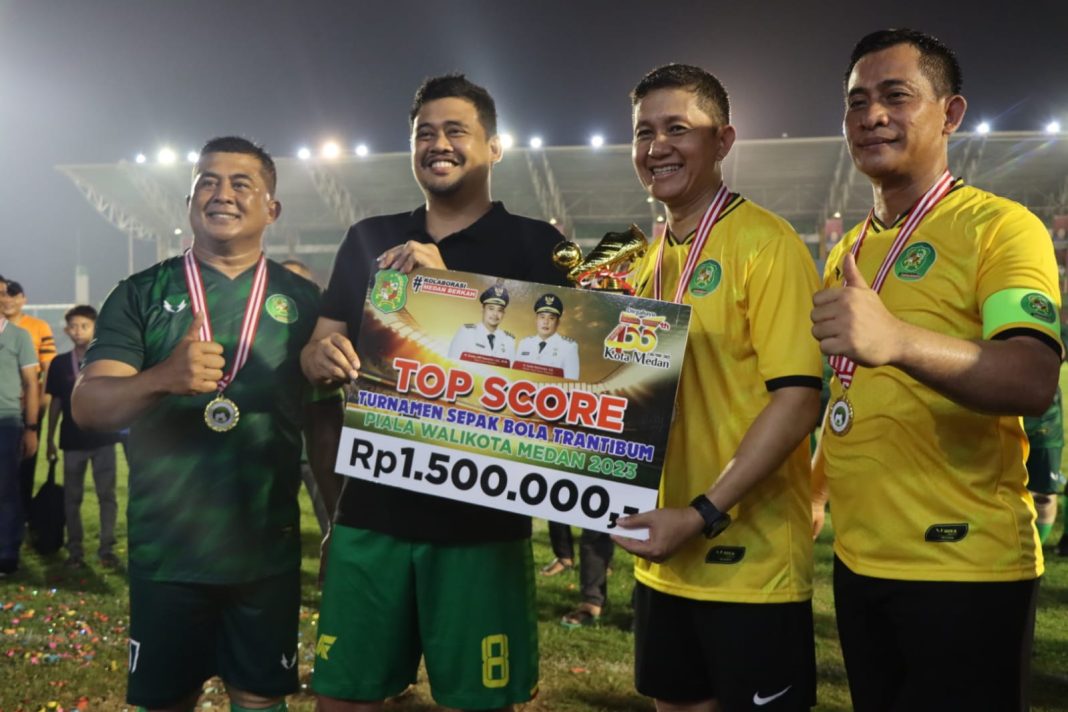 Wali Kota Medan Bobby Nasution memberikan hadiah kepada Kapolrestabes Medan Kombes Pol Valentino Alfa Tatareda SH SIK karena menjadi top skor pada turnamen sepak bola Trantibum di Stadion Teladan Medan, Minggu (16/7/2023). (Dok/Polrestabes Medan)