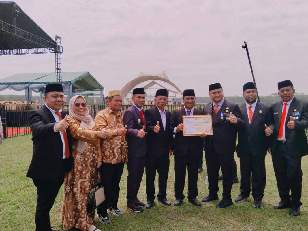 Ketua Dewan Pendidikan Labura Zurul Bakti Azis menerima piagam Penghargaan dari Bupati Hendri Yanto Sitorus berkaitan pelaksanaan program Kajian Ramadan yang digelar Dewan Pendidikan di Alun-alun Aekkanopan, Jumat (21/7/2023). (Dok/Dewan Pendidikan Labura)