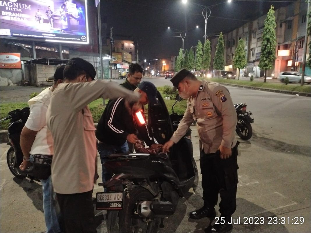 Personel Polrestabes Medan dan Polsek Medan Sunggal melakukan pemeriksaan terhadap kendaraan yang mencurigakan saat melintas di Jalan Gagak Hitam Ring Road, Rabu (26/7/2023). (Dok/Polrestabes Medan)