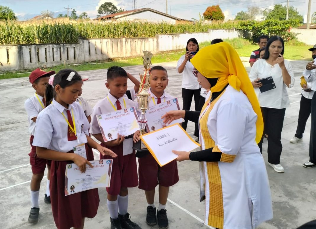 Kepala Bidang Pendidikan Dasar Hormauli Purba menyerahkan penghargaan kepada pemenang Lomba Cerdas Cermat tingkat Kabupaten Simalungun, di SD Negeri 091316 Unggulan Pamatangraya, Rabu (26/7/2023).