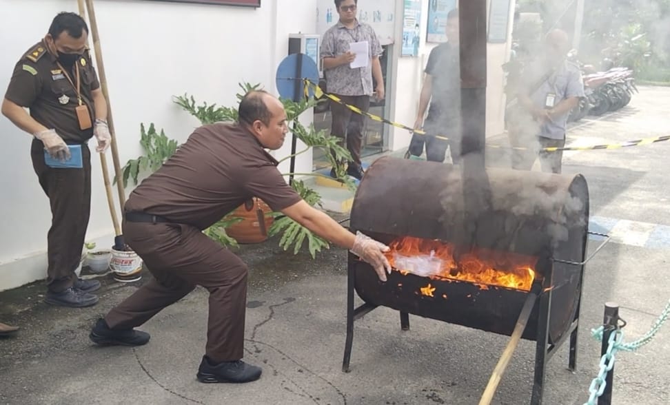 Kajari Asahan Dedyng Wibiyanto Atabay memusnahkan barang bukti narkotika dengan cara dibakar di Halaman Kejari Asahan, Kamis (27/7/2023).