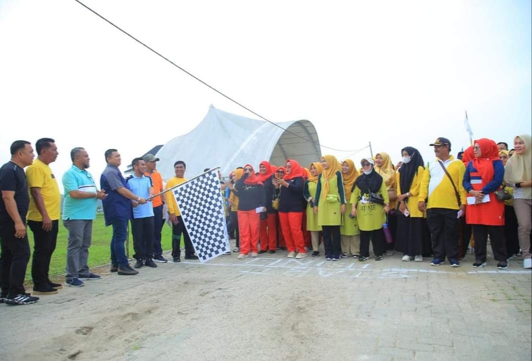 Bupati Labura Hendri Yanto Sitorus mengangkat bendera, menandai dilepasnya peserta jalan sehat yang digelar Dinas Pendidikan Labura berkaitan Gebyar Sekolah Sehat di Alun-alun Aekkanopan, Jumat (28/7/2023). (Dok/Kominfo Labura)