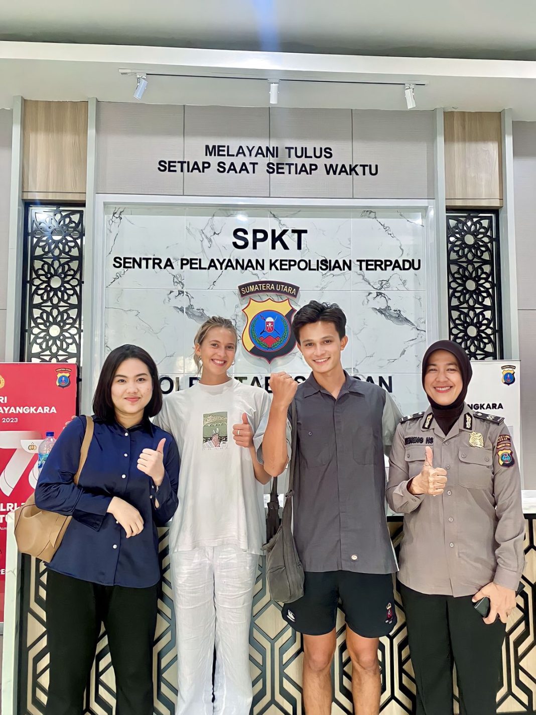 Personel SPKT Polrestabes Medan foto bersama usai melakukan problem solving terhadap dua WNA asal Inggris, Jhosua dan Yasmin di Mapolrestabes, Jumat (4/8/2023). (Dok/Polrestabes Medan)