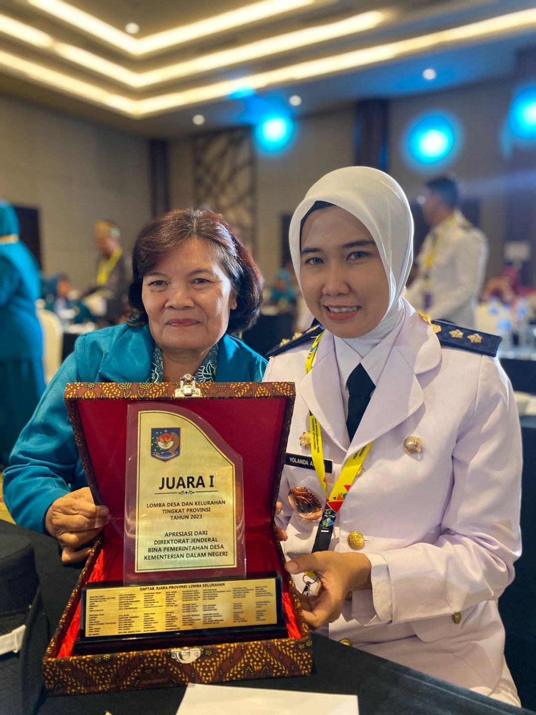 Lurah Mekar Sentosa Yolanda Amelia SSTP menunjukkan plakat juara 1, dalam acara TKN di Hotel Discovery, Ancol, Jakarta, Selasa (15/8/2023) malam. (Dok/Kominfo Tebingtinggi)