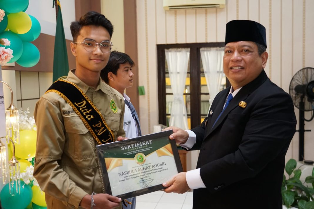 Pj Wali Kota Syarmadani memberikan penghargaan kepada Duta PN Tebingtinggi di Lapangan Pengadilan Negeri Tebingtinggi, Jalan 13 Desember, Sabtu (19/8/2023). (Dok/Kominfo Tebingtinggi)