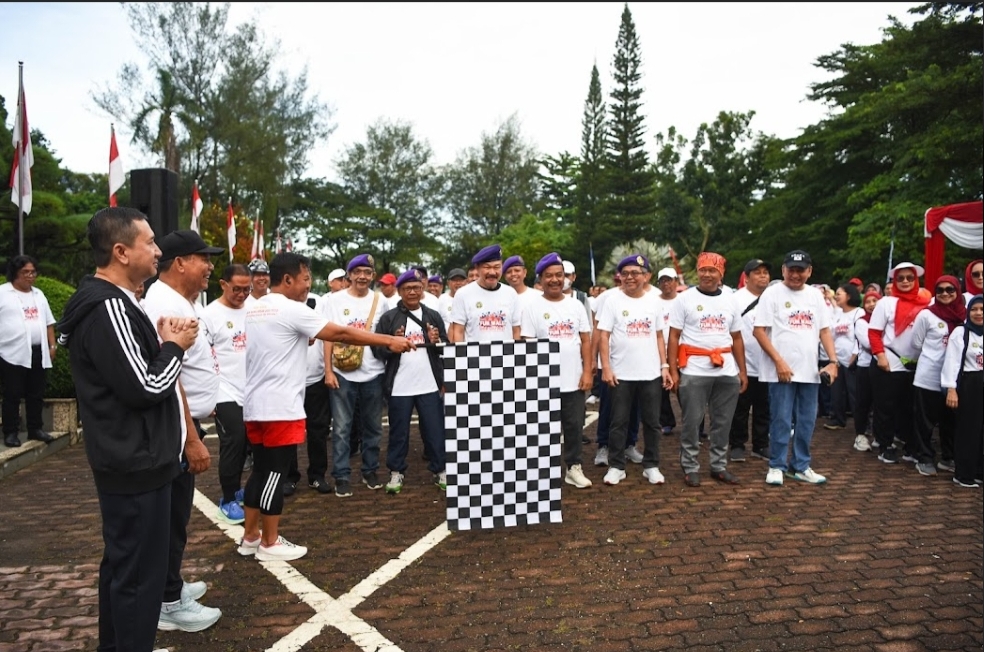 Rektor USU Prof Dr Muryanto Amin SSos MSi mengangkat bendera start saat melepas peserta Fun Walk bertemakan “Jalan Sehat Menopang USU Sehat 