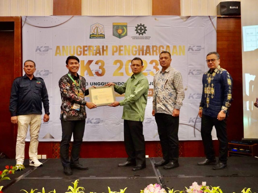 Kepala Dinas Tenaga Kerja dan Mobilitas Penduduk Aceh Akmil Husen SE MSi menyerahkan penghargaan kepada Kharisman Laia sebagai Team Leader K3L & Keamanan selaku mewakili manajemen. (Dok/PLN)