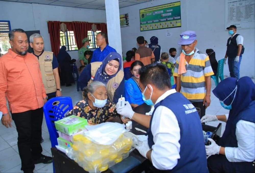 Sekda HM Suib dan Ketua IDI Labura dr Sugeng Hartono SpP menyaksikan tenaga kesehatan memeriksa kesehatan warga pada kegiatan bakti sosial IDI Labura di Desa Sialangtaji, Sabtu (2/9/2023). (Dok/Kominfo Labura)