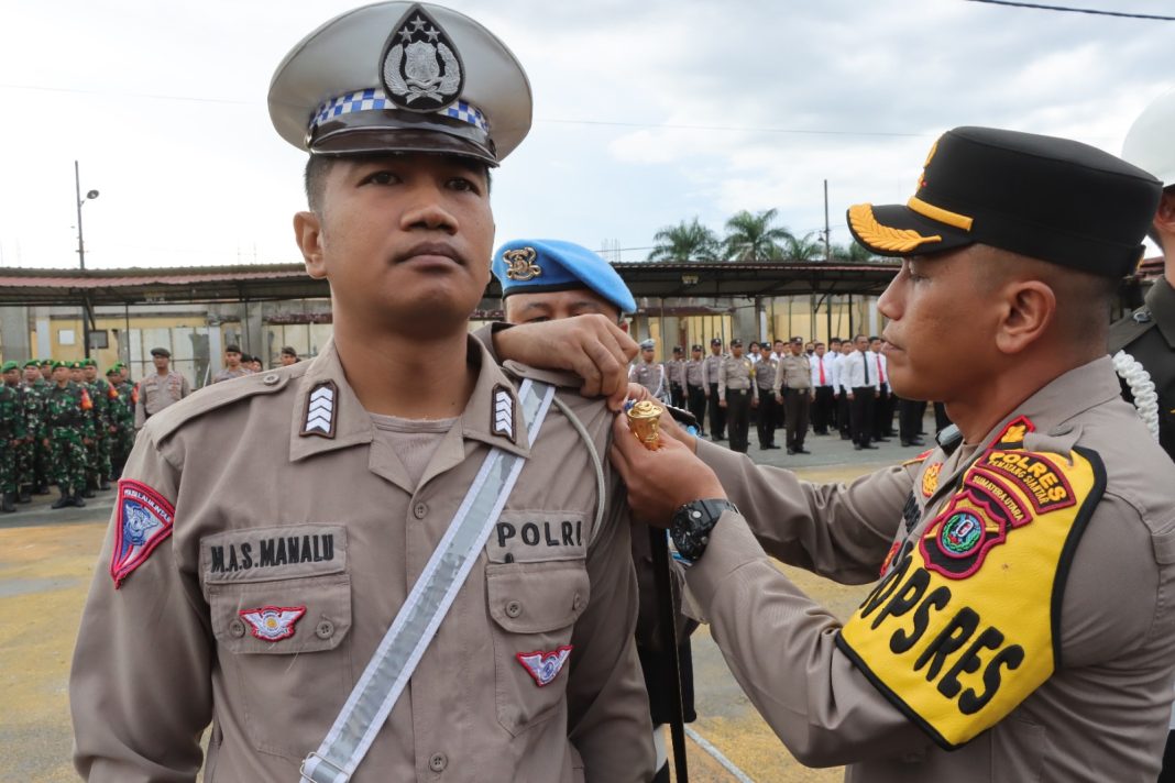 Kapolres Pematangsiantar AKBP Yogen Heroes Baruno SIK menyematkan pita kepada personel saat memimpin apel gelar pasukan Operasi Zebra Toba di Lapangan Mako Polres Pematangsiantar, Senin (4/9/2023). (Dok/Humas Polres Pematangsiantar)