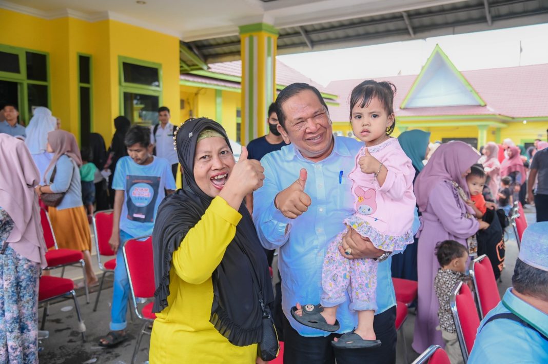 Wali Kota Padangsidimpuan Irsan Efendi Nasution SH MM berfoto dengan seorang anak pada acara penyaluran ZlS kepada 429 Mustahik di Kantor Wali Kota Padangsidimpuan, Minggu (10/9/2023). (Dok/Kominfo Padangsidimpuan)