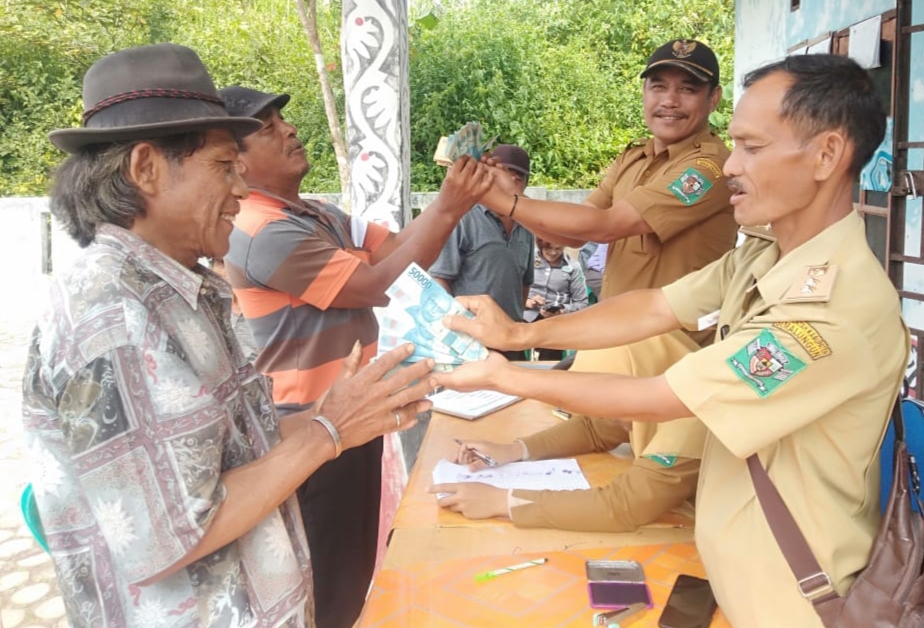 Pangulu Limagraya Kuatman Saragih (kanan) menyerahkan BLT-DD kepada Keluarga Penerima Manfaat di Limagraya, Kabupaten Simalungun, Senin (11/9/2023).