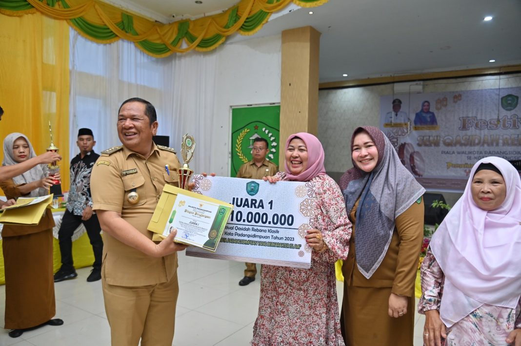 Wali Kota Padangsidimpuan Irsan Efendi Nasution SH MM sedang menyerahkan hadiah kepada Kecamatan Padangsidimpuan Utara perihal juara l Festival Qasidah Rebana Klasik tahun 2023 di Gedung H Adam Malik Padangsidimpuan, Selasa (12/9/2023). (Dok/Kominfo Padangsidimpuan)